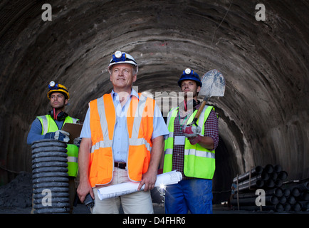 Businessman et workers standing in tunnel Banque D'Images