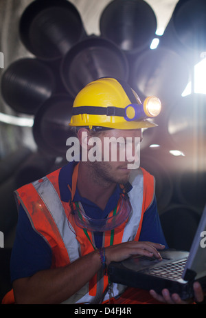 Worker using laptop in tunnel Banque D'Images