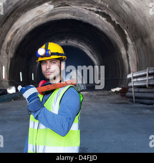 Worker holding sledgehammer dans tunnel Banque D'Images