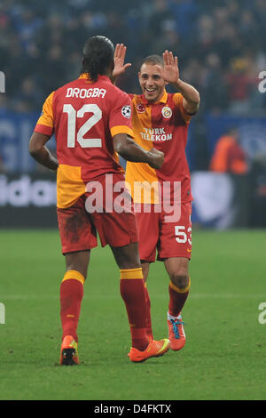 Le Galatasaray Didier Drogba (avant) et son coéquipier Nordin Amrabat cheer après l'UEFA Champions League round 16 match retour de match de football entre le FC Schalke 04 et galatasaray Istanbul à la Veltins-Arena de Gelsenkirchen, Allemagne, 12 mars 2013. Photo : Revierfoto Banque D'Images