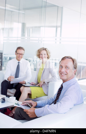 Business people talking in office lobby Banque D'Images