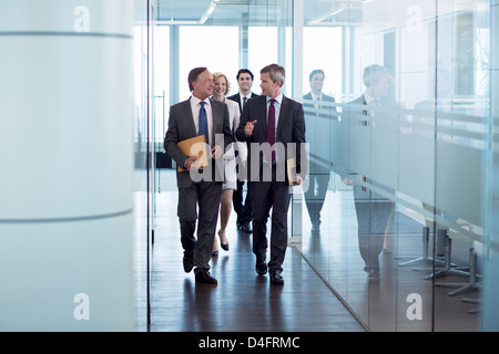 Businesspeople walking in hallway Banque D'Images