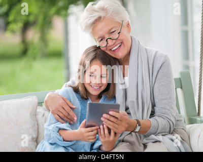 Woman and granddaughter using digital tablet Banque D'Images