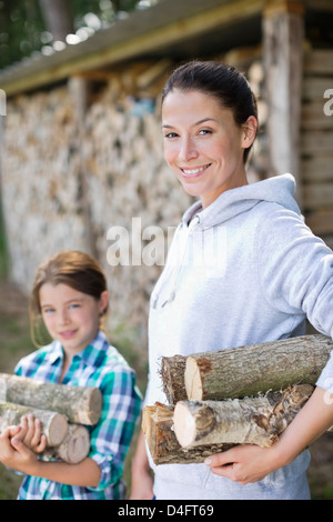 Mère et fille transporter le bois extérieur Banque D'Images