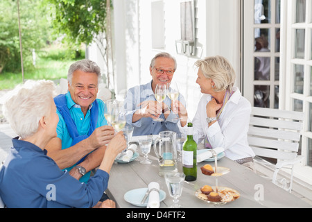 Friends toasting each other with wine outdoors Banque D'Images