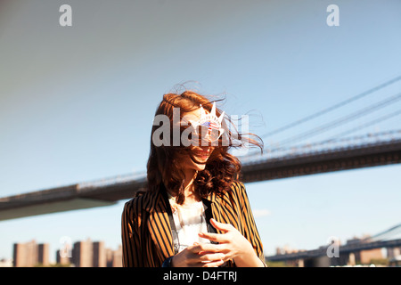 Femme dans la nouveauté des lunettes par ville paysage urbain Banque D'Images