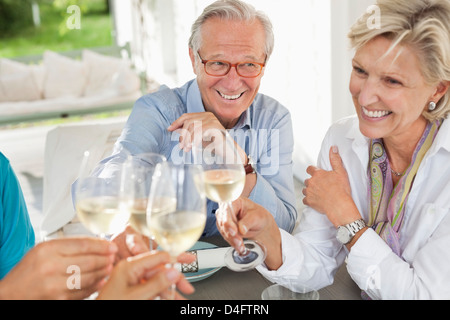 Friends toasting each other with wine Banque D'Images