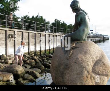 Un touriste prend une photo de la célèbre petite sirène dans le port de Copenhague, Danemark, 21 août 2008. Copenhague, sur 1,25 mètres de haut statue en bronze monument a été créé par le sculpteur danois Edvard Eriksen après la homonyme conte de Hans Christian Andersen. depuis le 23 août 1913, la Petite Sirène est assis patiemment sur le rocher. Photo : Thomas Borchert Banque D'Images