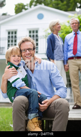 Père et fils smiling outside house Banque D'Images