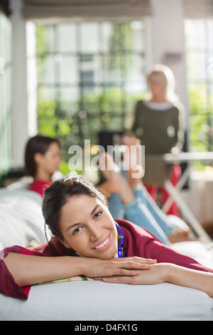 Smiling woman relaxing on sofa Banque D'Images