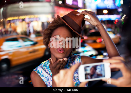 Couple taking pictures on city street Banque D'Images