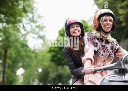 Les femmes équitation sur scooter together outdoors Banque D'Images