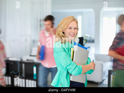 Businesswoman transportant folders in office Banque D'Images