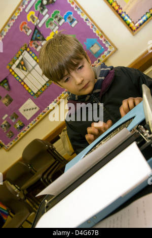 10 ans en tapotant le texte sur machine à écrire à un organisme de bienfaisance de la journée du livre de l'aide d'un coeur la charité (ben williams trust) Banque D'Images