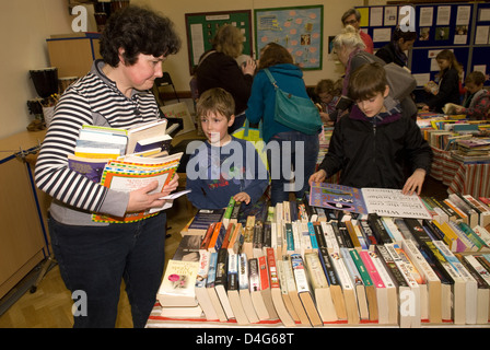 Les gens de lire des livres à un organisme de bienfaisance de la journée du livre de l'aide d'un coeur la charité Banque D'Images