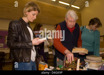 Les gens de lire des livres à un organisme de bienfaisance de la journée du livre de l'aide d'un coeur la charité Banque D'Images