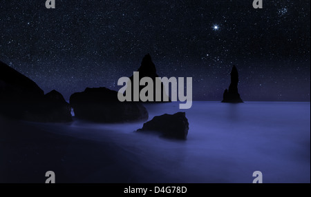 Ciel étoilé et falaises de Reynisdrangar, côte sud de l'Islande, digital composite Banque D'Images