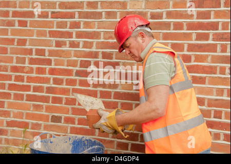 Charpentier la réparation du mur extérieur d'un bâtiment. Banque D'Images