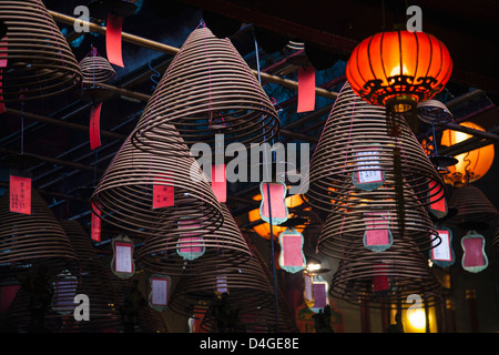 Lové dans la pendaison d'encens Temple Man Mo à Sheung Wan, Hong Kong. Banque D'Images