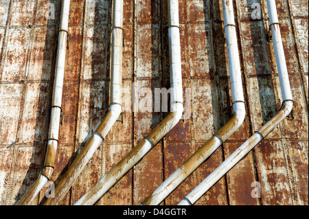 Les conduits rouillés sur le mur extérieur d'un bâtiment industriel abandonné. Banque D'Images