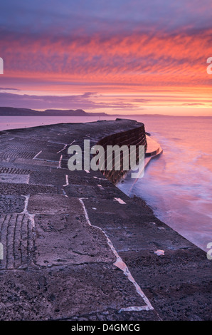 Hiver spectaculaire lever du soleil au-dessus du mur du port de Cobb, Lyme Regis, dans le Dorset, Angleterre. L'hiver (février) 2013. Banque D'Images