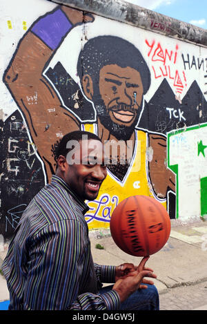 Joueur de basket-ball américain Gilbert Arenas (Washington Wizards) pose avec un terrain de basket-ball en face d'un graffiti à l'extérieur 'O2 Arena' à Berlin, Allemagne, 9 juillet 2008. 'Équipes NBA Washington Wizards' et 'New Orleans Hornets' se retrouveront face à face dans le champ de la "NBA Europe Live Tour' au nouveau 'O2 Arena' le 14 octobre 2008. Photo : SOEREN STACHE Banque D'Images