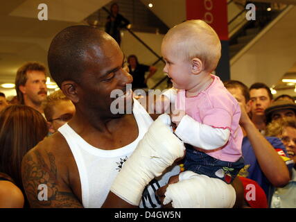 US boxer et Klitschko contender Tony Thompson pose avec huit mois "Leya" sur ses bras au cours d'une session de formation du public à un magasin de sport à Hambourg, Allemagne, 9 juillet 2008. Champion du monde en titre heavyweight Wladimir Klitschko à partir de l'Ukraine va essayer de défendre son titre IBF et WBO contre Tony Thompson à Hambourg, Allemagne, samedi, 12 juillet 2008. Photo : MA Banque D'Images