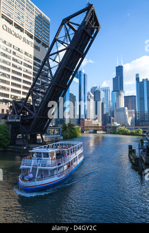 Excursion en bateau passant sous un pont ferroviaire sur la rivière Chicago, le centre-ville de tours à l'arrière-plan, Chicago, Illinois, États-Unis Banque D'Images