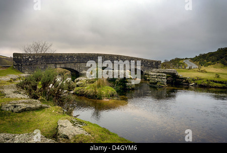 Un vieux pont en pierre avec les vestiges d'un ancien clapper granit pont sur une rivière dans le parc national du Dartmoor dans le Devon. Banque D'Images