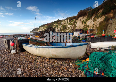 Un bateau de pêche avec des filets et des casiers à homard sur la plage de la bière sur la côte jurassique du Devon Banque D'Images