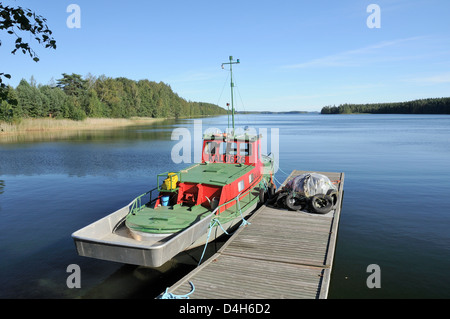 Bateau amarré à une jetée sur le lac Puruvesi, une branche du lac Saimaa près de Kerimaki, Finlande, Scandinavie Banque D'Images