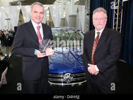 Le PDG de VW USA, Stefan Jacobi (L) pose avec l ?Green Voiture de l'année 2008 ? Prix, sa société a reçu pour sa Jetta limousine (vu dans l'arrière-plan) à côté de l'éditeur de la ?Green Car Journal ?, Ron Cogan, au Los Angeles Auto Show de Los Angeles, USA, 20 novembre 2008. Depuis 2005 le prix de la voiture plus respectueux de l'environnement est décerné par un jury composé de edito Banque D'Images