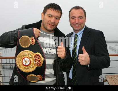 Le Champion du Monde Poids Lourds WBA Ruslan Chagaev (L), pose avec sa ceinture de champion et son entraîneur Michael Timm (R) de ?Universum Box-Promotion ? Poser pour les photographes à ?Yachthafenresidenz Hohe Duene ? Dans la région de Rostock, Allemagne, 16 décembre 2008. Suite à une grave blessure du tendon d'achille, Chagaev se battra contre Carl Davis Drumond à Rostock, Allemagne, 7 février 2009. Photo : Banque D'Images