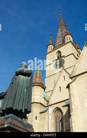 Statue de Mgr Jean-Claude Rambaud avec tour de l'horloge de la cathédrale luthérienne de Sibiu, en Transylvanie, Roumanie Banque D'Images