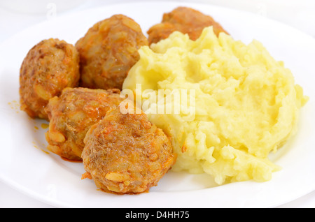 Noisettes avec de la purée de pommes de terre sur une plaque blanche Banque D'Images