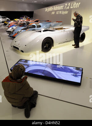 Les visiteurs prendre un regard sur les voitures de course Porsche dans le musée Porsche à Stuttgart, Allemagne, 31 janvier 2009. Le musée dans un bâtiment futuriste ouvert pour le public pour la première fois le 31 janvier. Certaines voitures de sport 80 illustrent l'histoire de l'entreprise. Photo : MARIJAN MURAT Banque D'Images