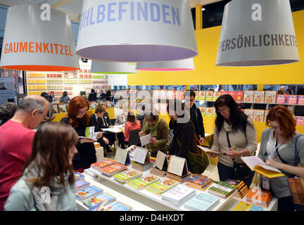 Les visiteurs regarder à travers des livres sur le stand des éditeurs de GU à la Foire du livre de Leipzig à Leipzig, Allemagne, 14 mars 2013. Plus de 2 000 maisons d'édition sont présentés à la foire, qui a lieu jusqu'au 17 mars. Photo : Photo : HENDRIK SCHMIDT Banque D'Images