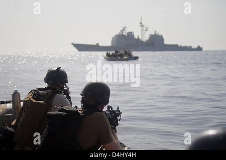 Le croiseur à missiles guidés USS Anzio (CG 68) de l’US Navy mène une opération de perquisition et de saisie. Cette opération démontre la capacité de la Marine de mener des actions d'application de la loi pendant les missions de sécurité maritime. Banque D'Images