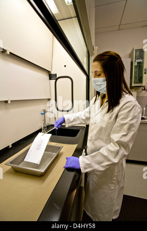 Salle de traitement de la preuve Santa Ana, CA, un service de police en matière de médecine légale, un technicien de laboratoire portant un masque de protection Banque D'Images