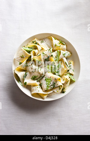 Une assiette de pâtes pappardelle avec ricotta crémeuse, bébés épinards, fines herbes et poivre noir. Banque D'Images