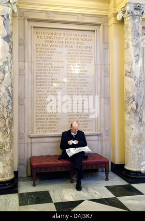 Un homme assis par le War Memorial, Aston Hall Building, Edgbaston campus, l'Université de Birmingham, UK Banque D'Images