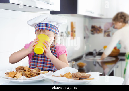 Petite fille mignonne boire du lait dans la cuisine Banque D'Images