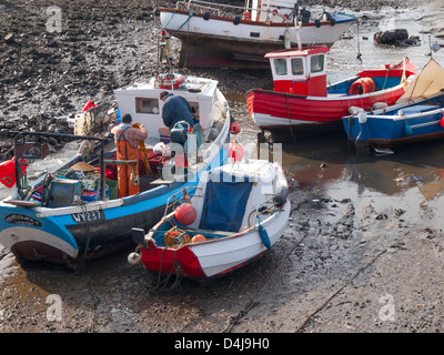 Les hommes qui travaillent dans un bateau de pêche échoué à marée basse dans le port de trou Rhône-Alpes, Teesmouth, Redcar Cleveland UK Banque D'Images