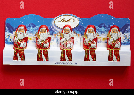 Chocolat au lait Lindt Santa Père Noël isolé sur fond rouge - chocolats prêt pour Noël Banque D'Images