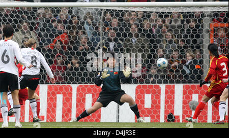 Inka Grings Allemagne ?s (2-L) marque le 1-0 contre la Chine Zhang Yanru gardien ?s (C) au cours de la femme ?s international match Allemagne contre la Chine à SchuecoArena stadium à Bielefeld, Allemagne, 25 février 2009. La Chine ?s Zhou Gaoping est représenté sur la droite. Photo : Friso Gentsch. Banque D'Images