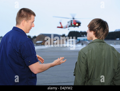 Les élèves du lycée de Kodiak ont eu l'occasion d'assister Charly Hengen, technicienne en survie aéronautique, d'acquérir des connaissances précieuses sur les opérations de la station aérienne et l'utilisation de l'hélicoptère MH-60 Jayhawk pour les missions de sauvetage et la formation à la survie. Banque D'Images