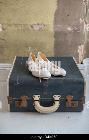 Shoes sitting on suitcase antique Banque D'Images