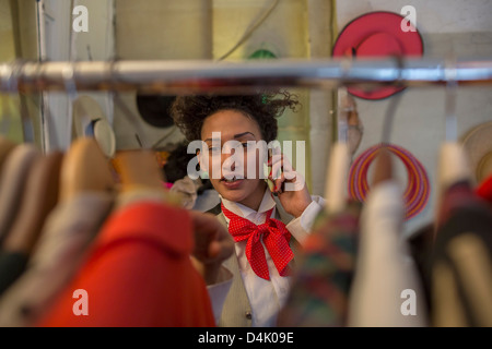 Woman on cell phone in clothes shop Banque D'Images