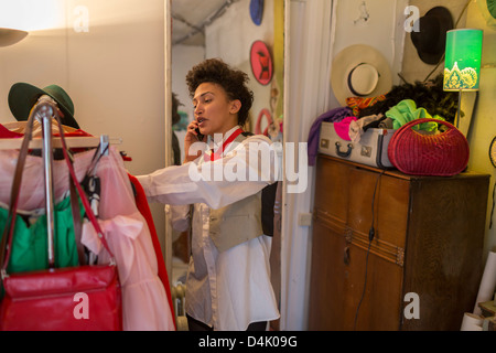 Woman on cell phone in clothes shop Banque D'Images