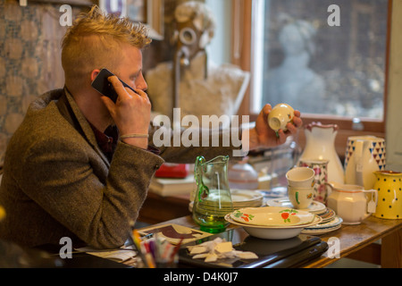 Man talking on cell phone at table Banque D'Images